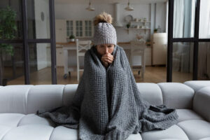 A woman wrapped in a blanket on a couch.