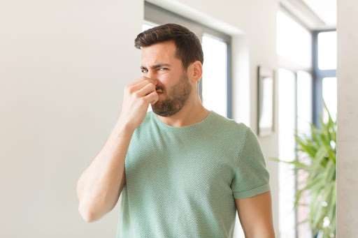 A man holding his nose in a home.