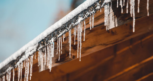 A roof and pipe with ice.