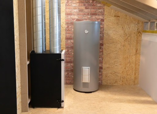 Grey Electric storage water heater with Temperature Display in utility room, brick wooden wall.