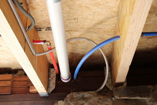 Red and blue PEX piping in a ceiling.