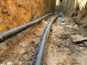 Geothermal ground loop system being installed in trench.