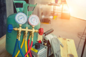 A canister of refrigerant next to a pair of gloves.