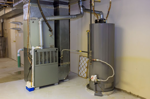 A water heater tank installed next to a heating system.