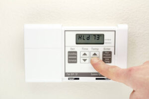 Homeowner's finger programming thermostat.