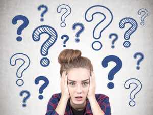 Woman holding her head in her hands while surrounded by question marks.